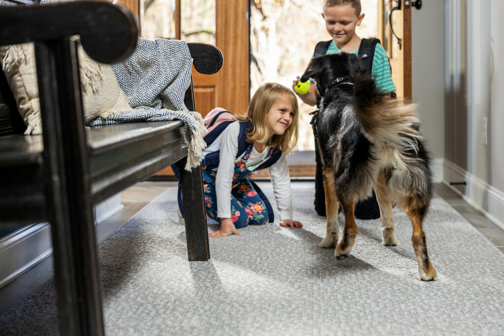 Kids playing with dog on carpet floors | Hernandez Wholesale Flooring